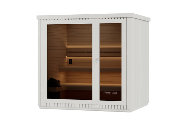 Nordhaus sauna cabinet in white with glass doors, showing warm interior lighting and wooden shelves, isolated on a white background.