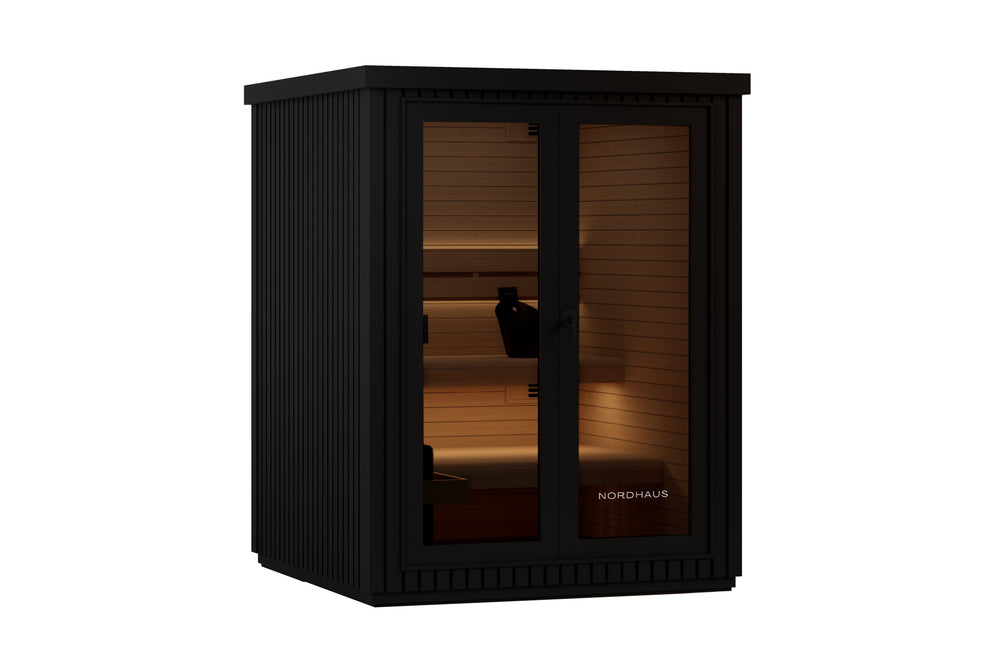 Black outdoor traditional sauna with matte aluminium cladding, warm timber interior, tiered benches, LED lighting and a full glass front door.