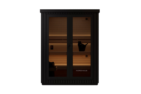 Nordhaus black wooden sauna cabinet with glass doors, illuminated from within showing wooden shelves and a bucket, isolated on a white background.